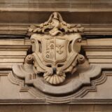 Stemă sculptată în piatră deasupra intrării unei clădiri vechi dintr-un oraș medieval
