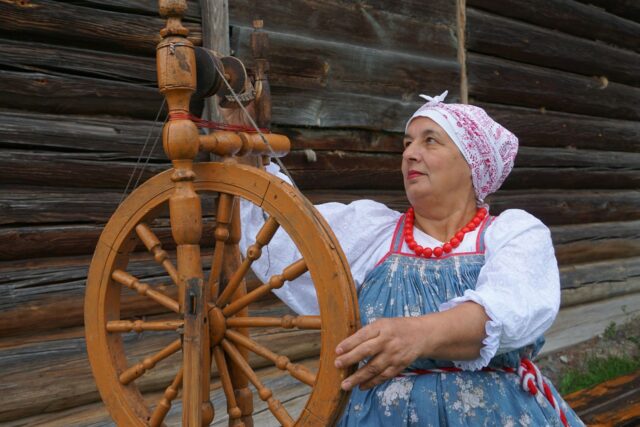 Călăreți în costume tradiționale, cu cai împodobiți, pe o stradă veche dintr-un oraș transilvănean